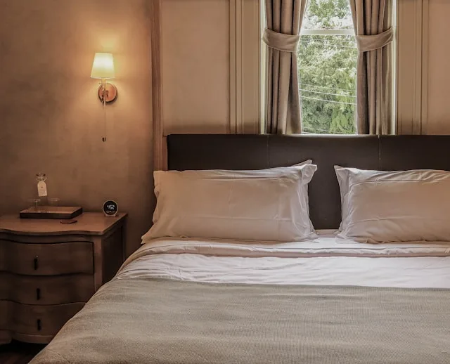 Slaapkamer van een B&B met opgemaakt bed en raam